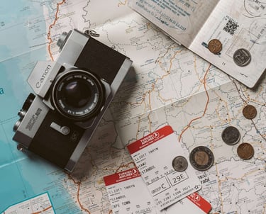 Putna karta, fotoaparat, avionske karte, putovnica i kovanice.