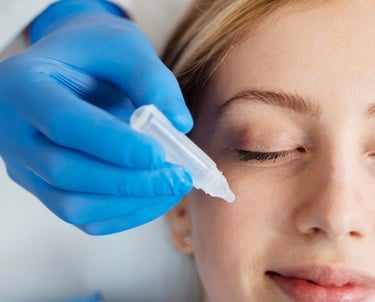 Vrouw met een chirurgisch handschoen aan dat vloeistof op een gezicht aanbrengt