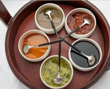a wooden tray with sauces