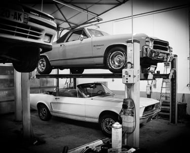 a car is parked on a lift in a garage, chevrolet, mustang