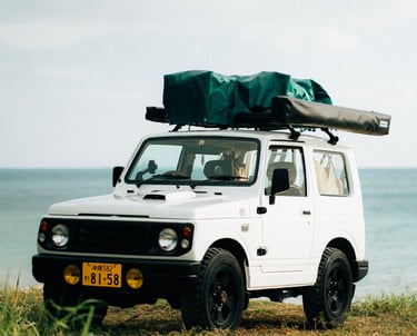 Suzuki Jimny with camping gear on the roof, parked by the ocean in Okinawa | Evertrail Okinawa