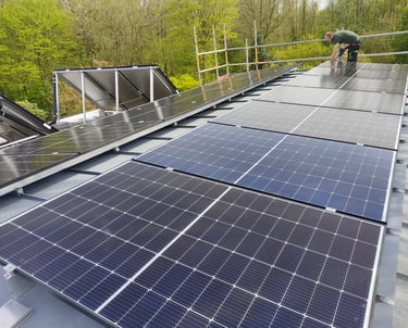 Ein Mann steht auf einem Dach mit Solarpaneelen.