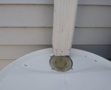 a photo of a rain barrel installed under a cut downspout for collecting rainwater