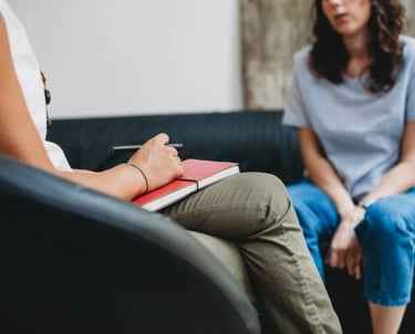 Duas mulheres sentadas em um consultório, em uma sessão de aconselhamento ou terapia.
