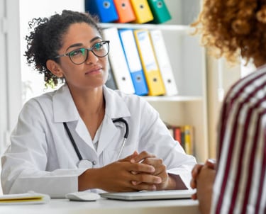 Uma profissional da saúde mental e sua paciente conversando em um atendimento presencial.