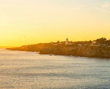 Falaises de Cascais vues de la mer au coucher du soleil, Portugal.