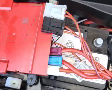 BMW car battery with electrical components attached 