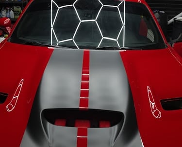 Red Dodge Challenger with silver racing stripes and honeycomb vinyl accents
