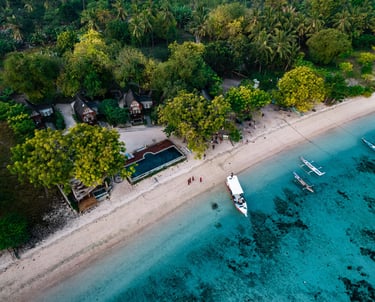 a dive boat is parked on the shore of a beach next to a resort