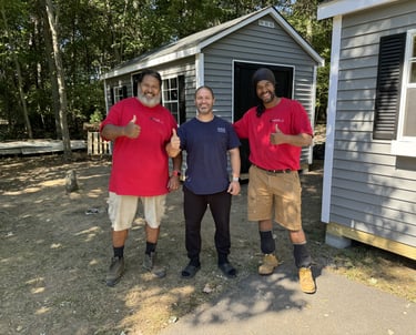 Satisfied customer standing with Imperial Custom Sheds team after shed installation