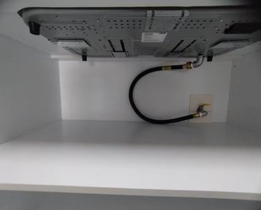 A black flexible gas pipe connecting home appliance with main gas line