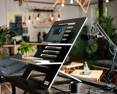 Estantería con portatil y tablet en una oficina con flores y micrófono