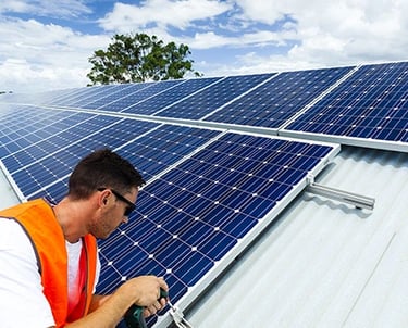 Professional technician installing solar panels on a residential rooftop for renewable energy.