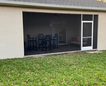 a patio with a table and chairs in the grass