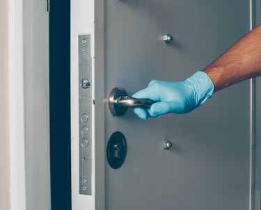 a person in gloves and gloves is holding a door handle