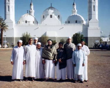 a group of people standing in front of the Quba Mosque in Medina Almunawara