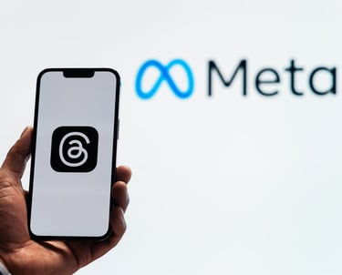 Mano sosteniendo celular mostrando aplicaciones de meta