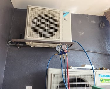 Suasana Aircond technician checking refrigerant pressure for Daikin repair.