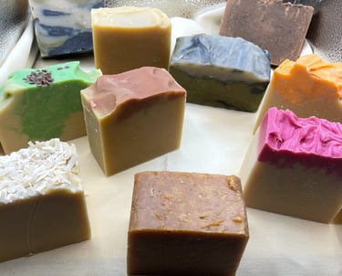 Assorted handcrafted goat milk soap bars in a variety of natural colors and scents