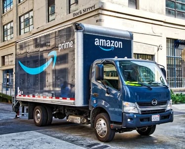 a truck with an amazon logo parked in front of a building
