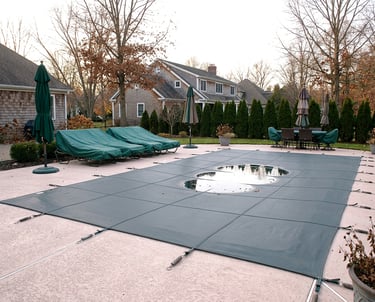 Closing pools for winter Central New York with a covered residential pool in a backyard prepared for