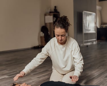 a woman in a white shirt is stretching out her arms and hands