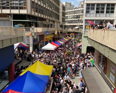 Vista da Rua José Paulino com clientes e tendas coloridas no bom retiro