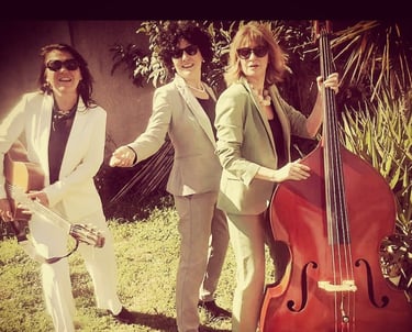 trois femmes en costume avec une contrebasse et une guitare