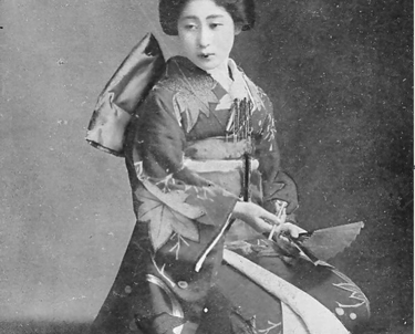 Historische Schwarzweißfotografie einer traditionell gekleideten japanischen Frau im Kimono, kniend