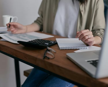 Assistante administrative : calculatrice et nombreux papiers triés et rangés, gestion des commandes