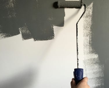 Ouvrir qualifié : rouleau de peinture gris sur un mur blanc