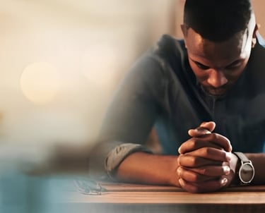 un homme assis à une table avec un ordinateur portable et un téléphone portable