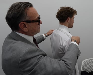 a man in a suit and tie is helping a man fix his tie