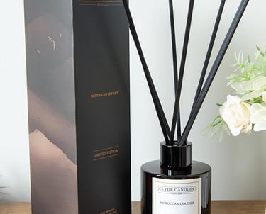 Oakmoss & Cedarwood Reed Dia black and white diffuser with a black box and a white vase with flowers