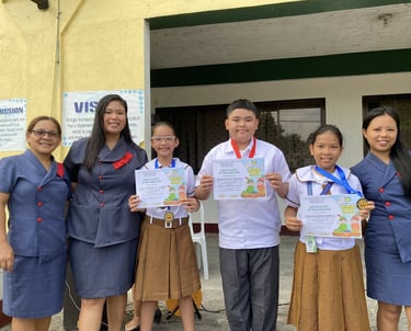 Groups of elementary students holding certifications with teachers