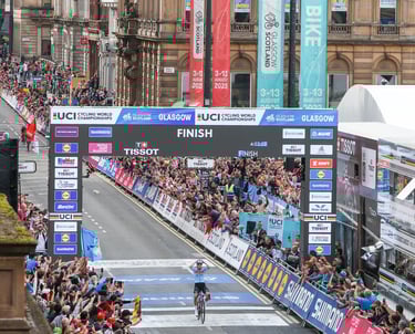 A professional bike riders winning a race whilst thousand of people watch and support
