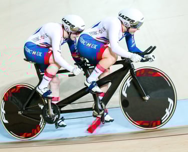 athletes racing a tandem on a velodrome