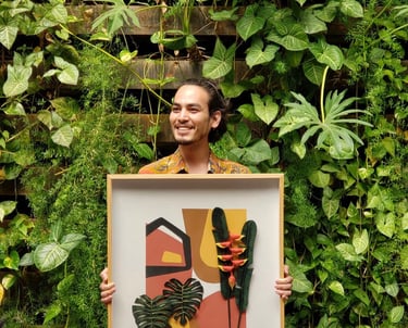 a man holding a framed print of a painting of a plant