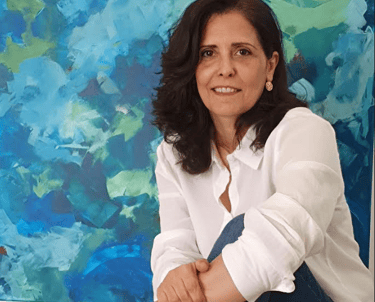 a woman sitting on a couch in front of a painting