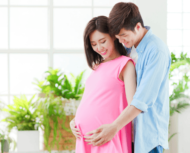 Pregnant lady hugged from back by a supportive and caring partner