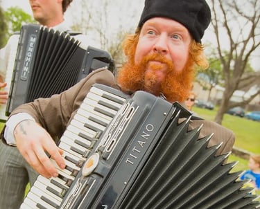 Dylan Blackthorn playing accordion during a live Mazel Tov Kocktail Hour show