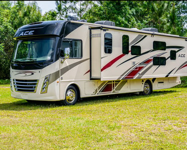 A modern Thor Motor Coach A.C.E. Class A motorhome parked on grass with a slide-out extended.