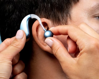 a man with a silver earpieces is putting a silver earpiece on his