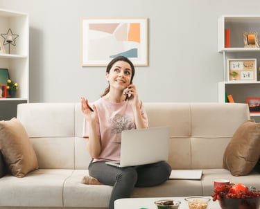 a woman sitting on a couch talking on her cell phone