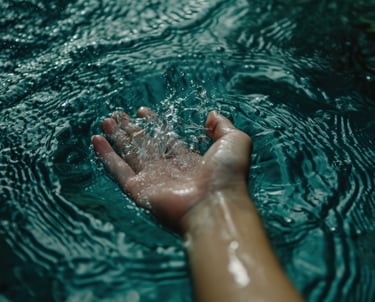 a person's hand holding a hand in the water