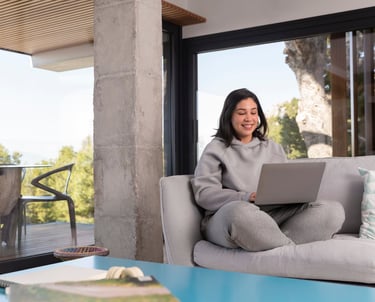a woman sitting on a couch with a laptop computer