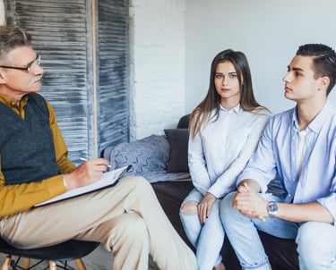 a man and woman sitting on a couch in a living room