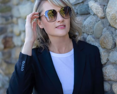 a woman in a black suit and sunglasses