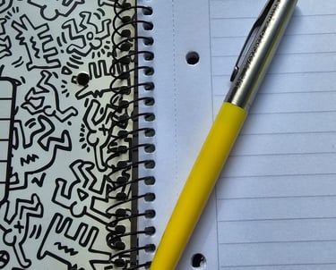 A yellow pen over an open notebook ready for create content.