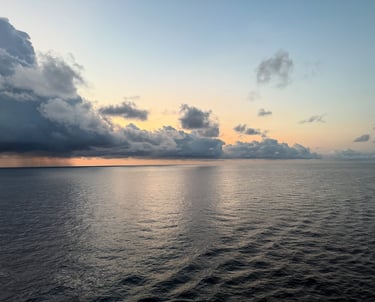 a boat in the water with clouds in the background